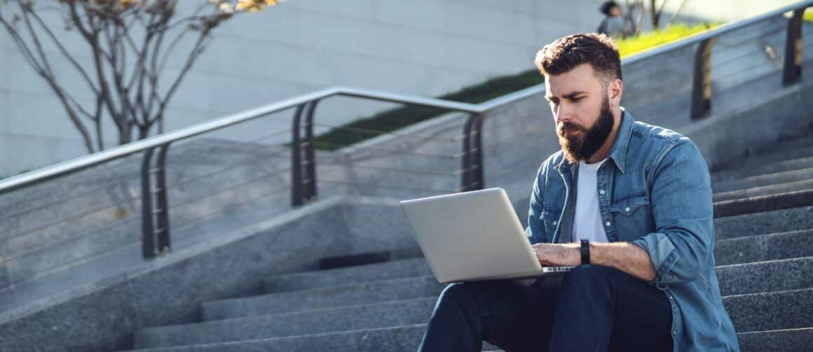 Man sitting on stairs with desktop